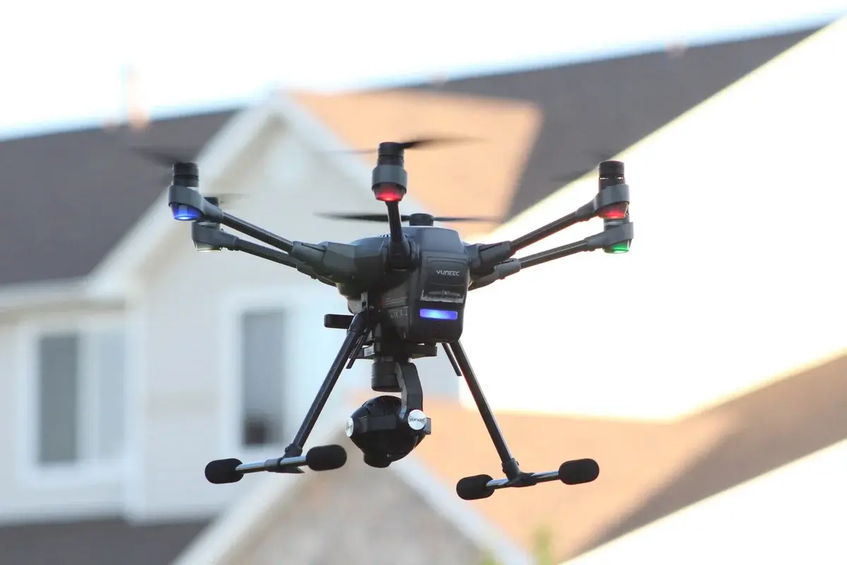 A drone flying in front of a house.