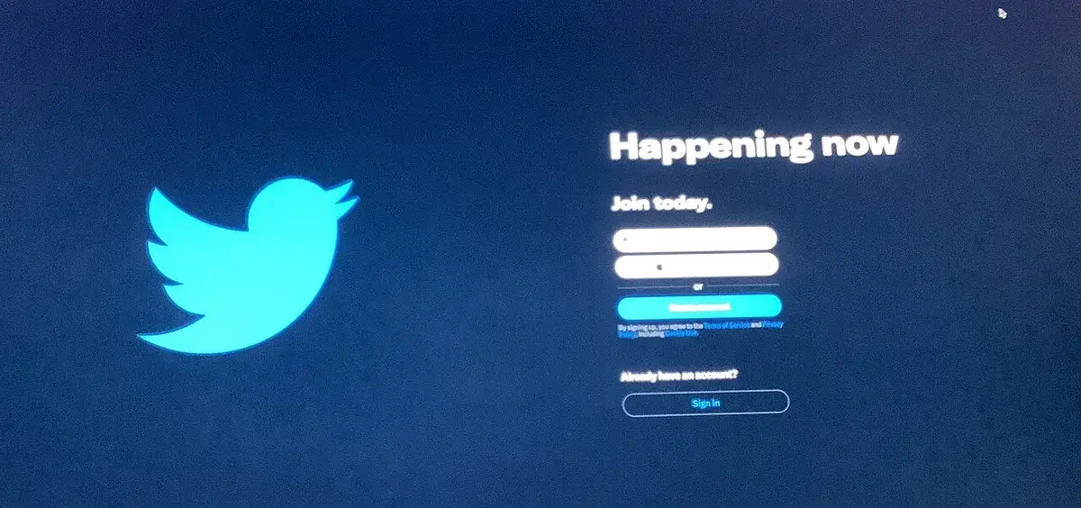 Twitter homepage sign-up screen with the bird logo and login fields.