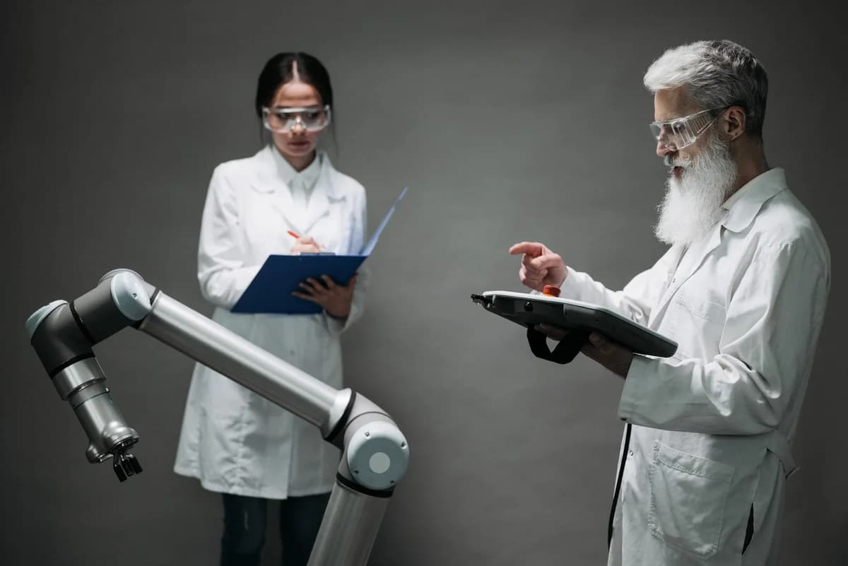 Two scientists in a lab working with a robotic arm.