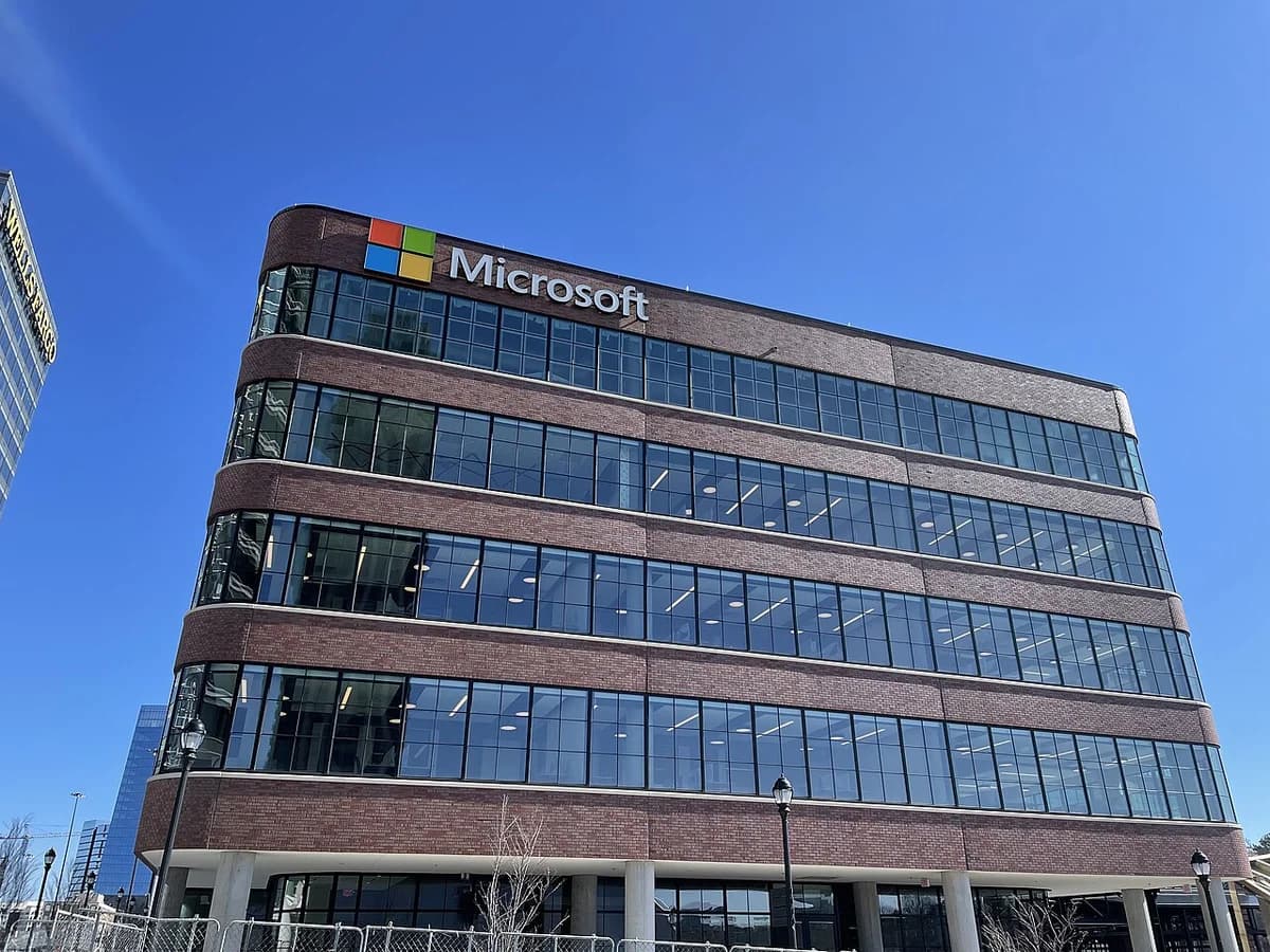 Microsoft office building with a brick and glass facade under a blue sky.