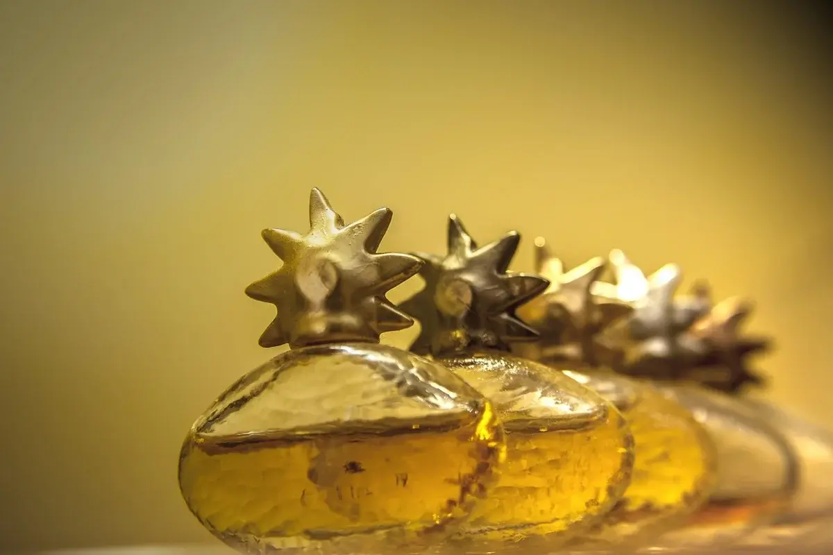 Close-up of decorative perfume bottles with gold star-shaped caps.