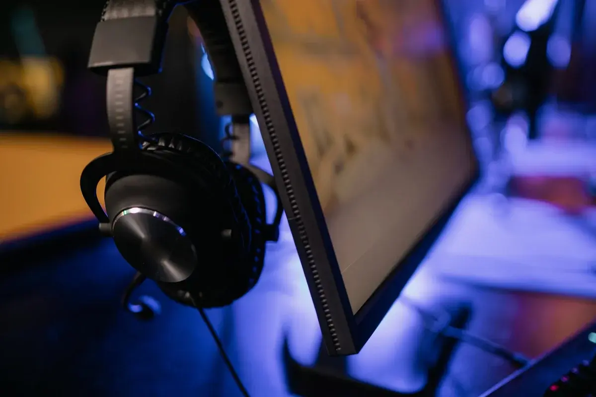 Close-up of a gaming monitor with headphones attached.