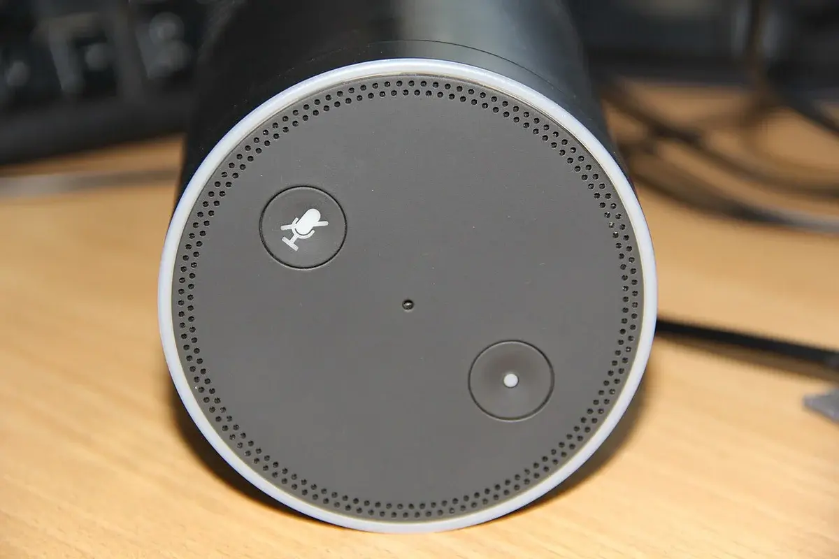 Close-up of an Amazon Echo Plus smart speaker on a wooden surface.