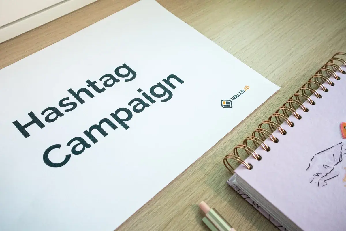 Desk with a hashtag campaign sheet and a spiral planner.