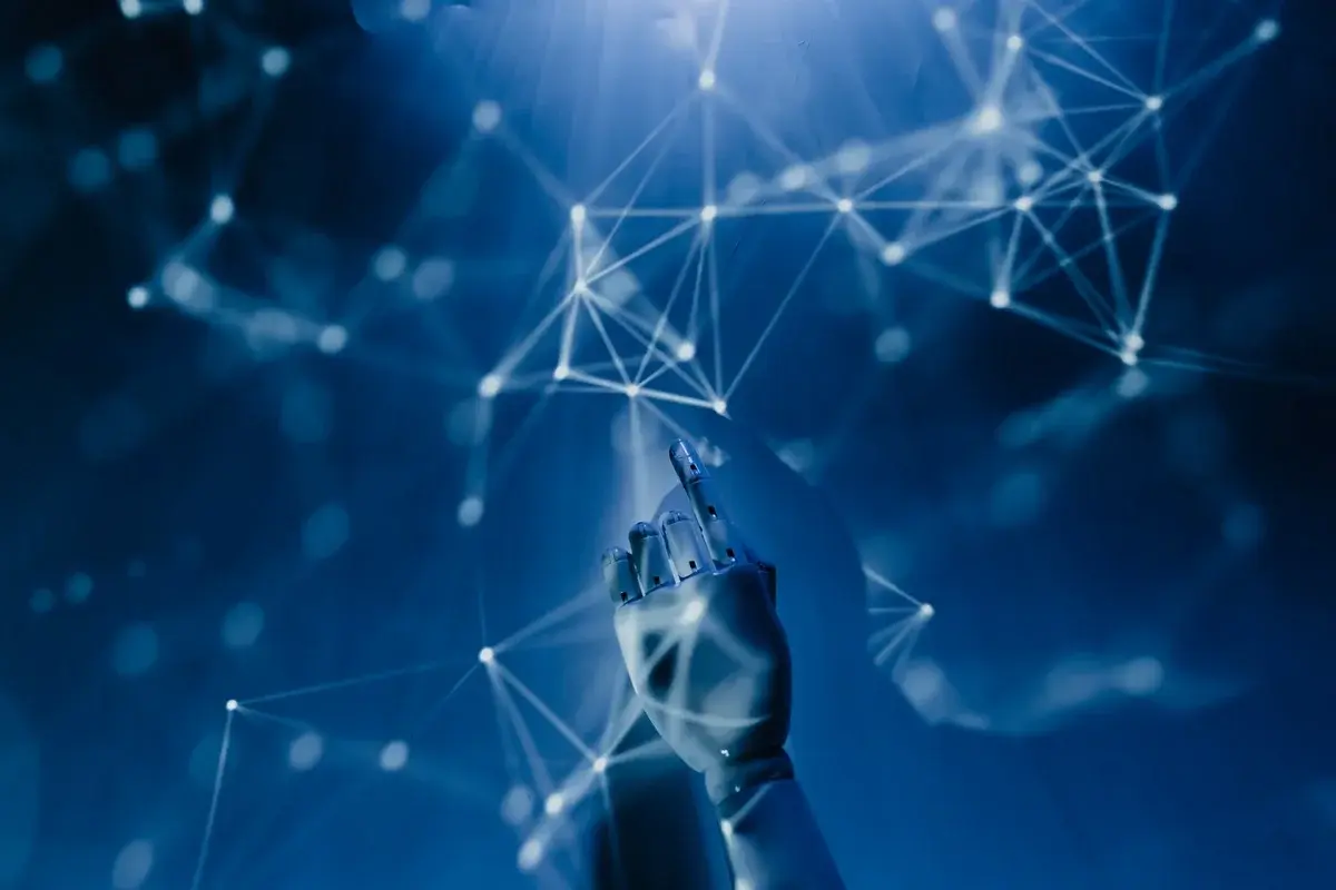 A robotic hand reaching toward a digital network of glowing nodes on a blue background.