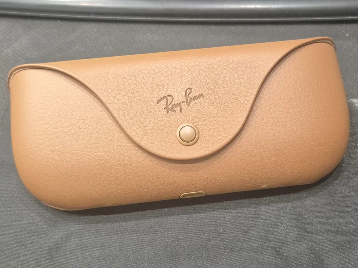 A tan Ray-Ban case with a logo on the front, shown closed.