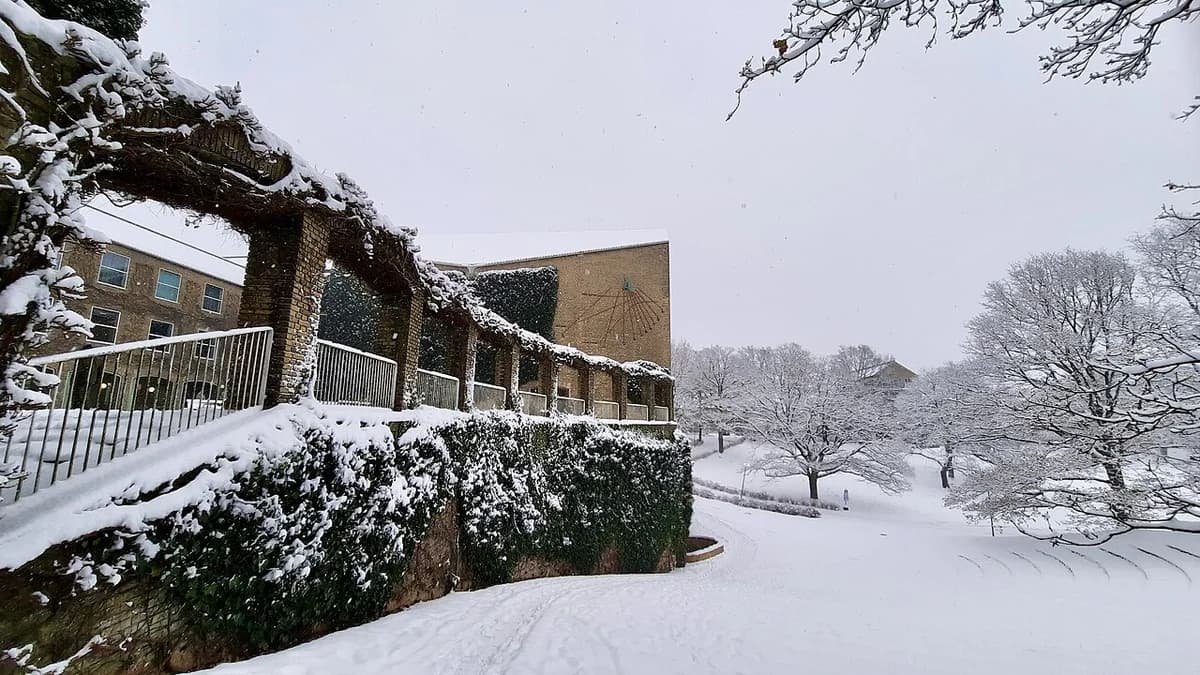 Snow-covered path and AULA building at Aarhus University in winter.