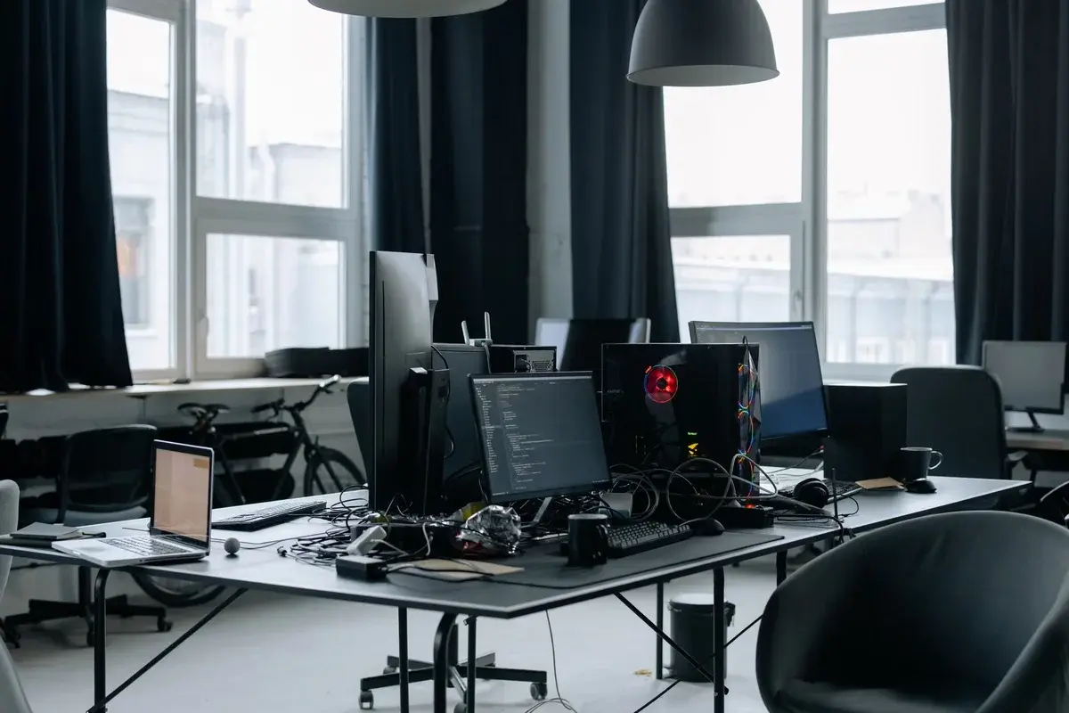 Modern office workspace with computers and coding screens.