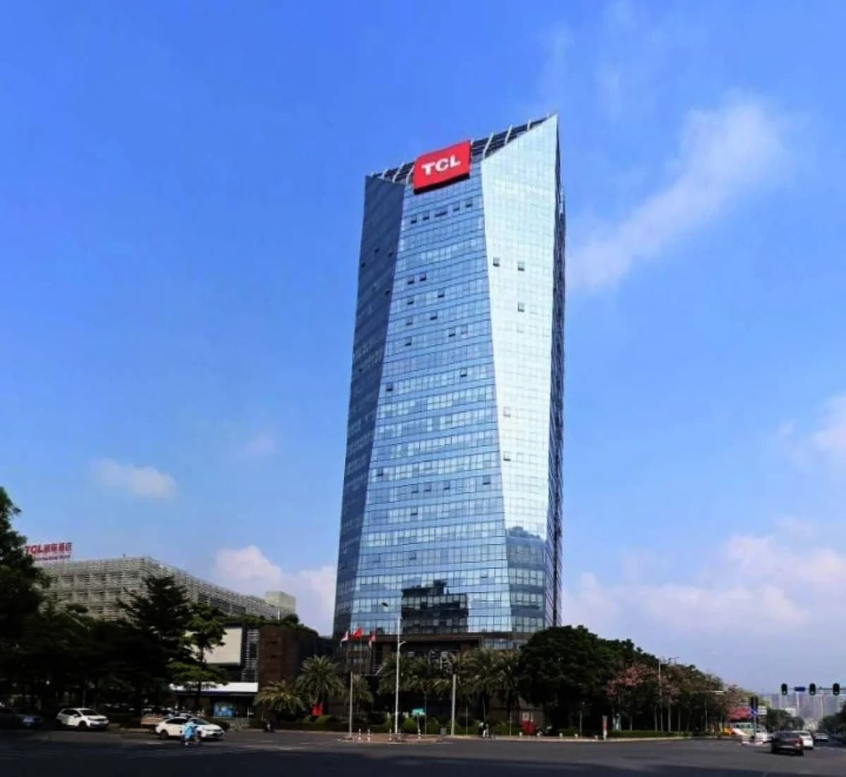 A glass office tower with a TCL sign at the top.