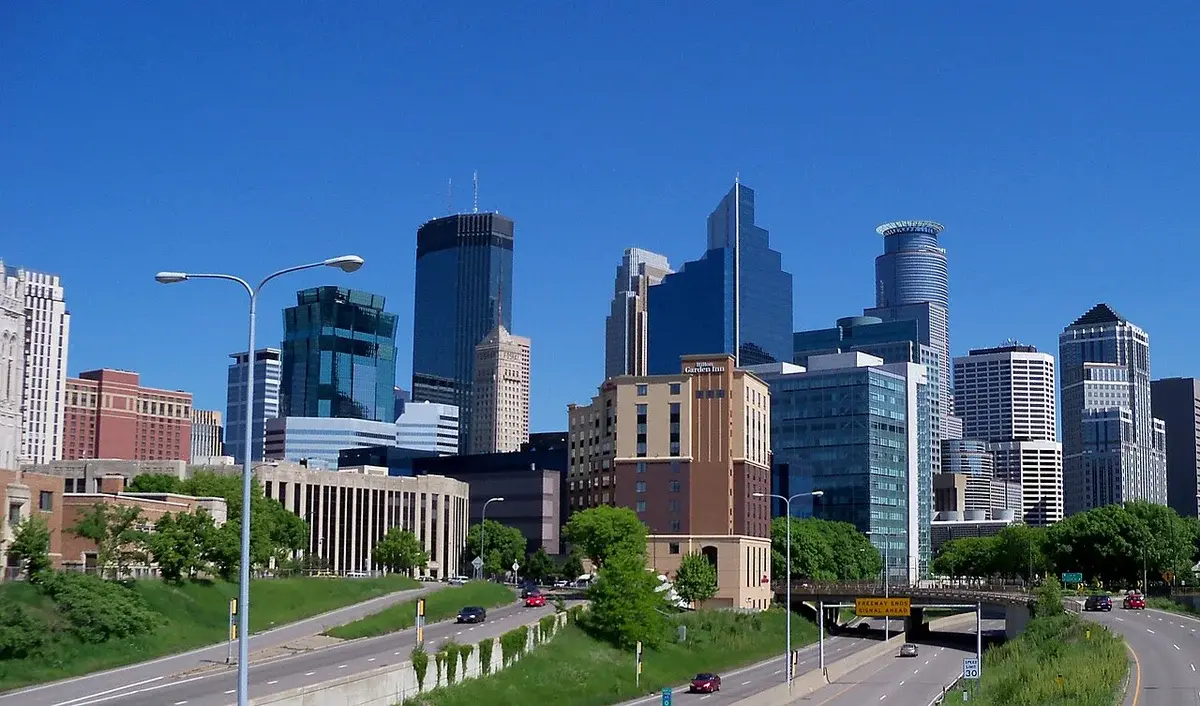 Daytime view of the Minneapolis skyline with highways in the foreground.
