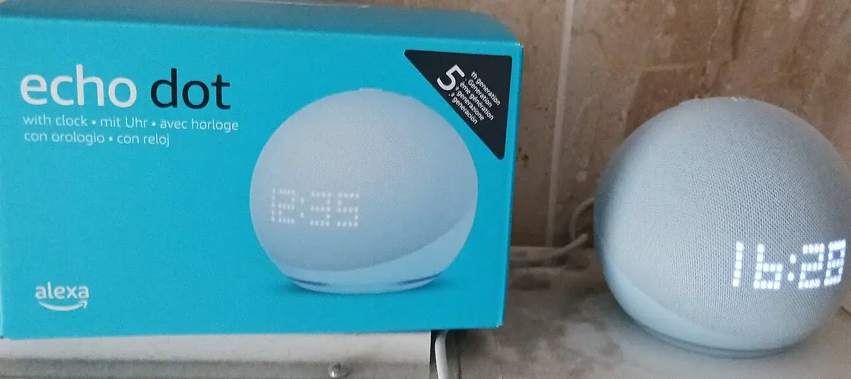 Amazon Echo Dot 5 smart speaker with clock display, shown beside its box.