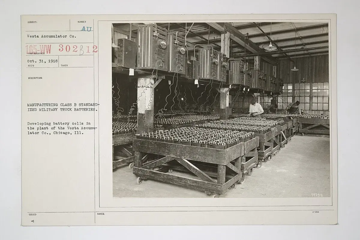 Historical factory photo of workers developing battery cells for military truck batteries.