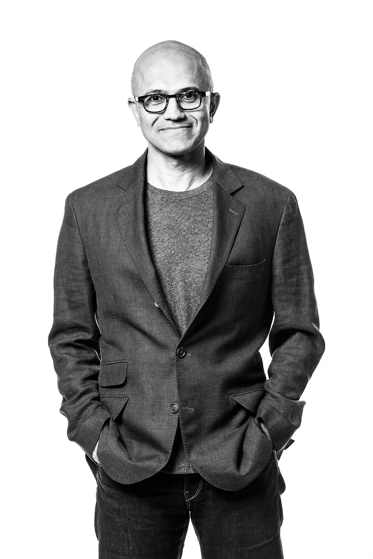 Black-and-white portrait of Satya Nadella standing against a white background.