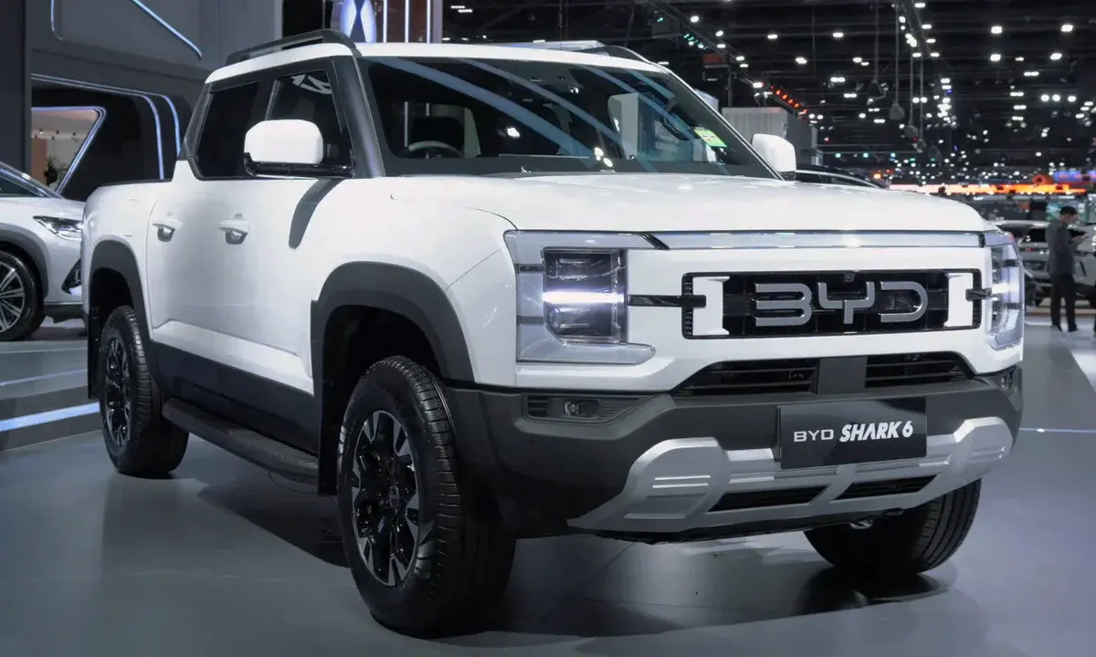 White BYD Shark 6 pickup truck on display at an auto show.