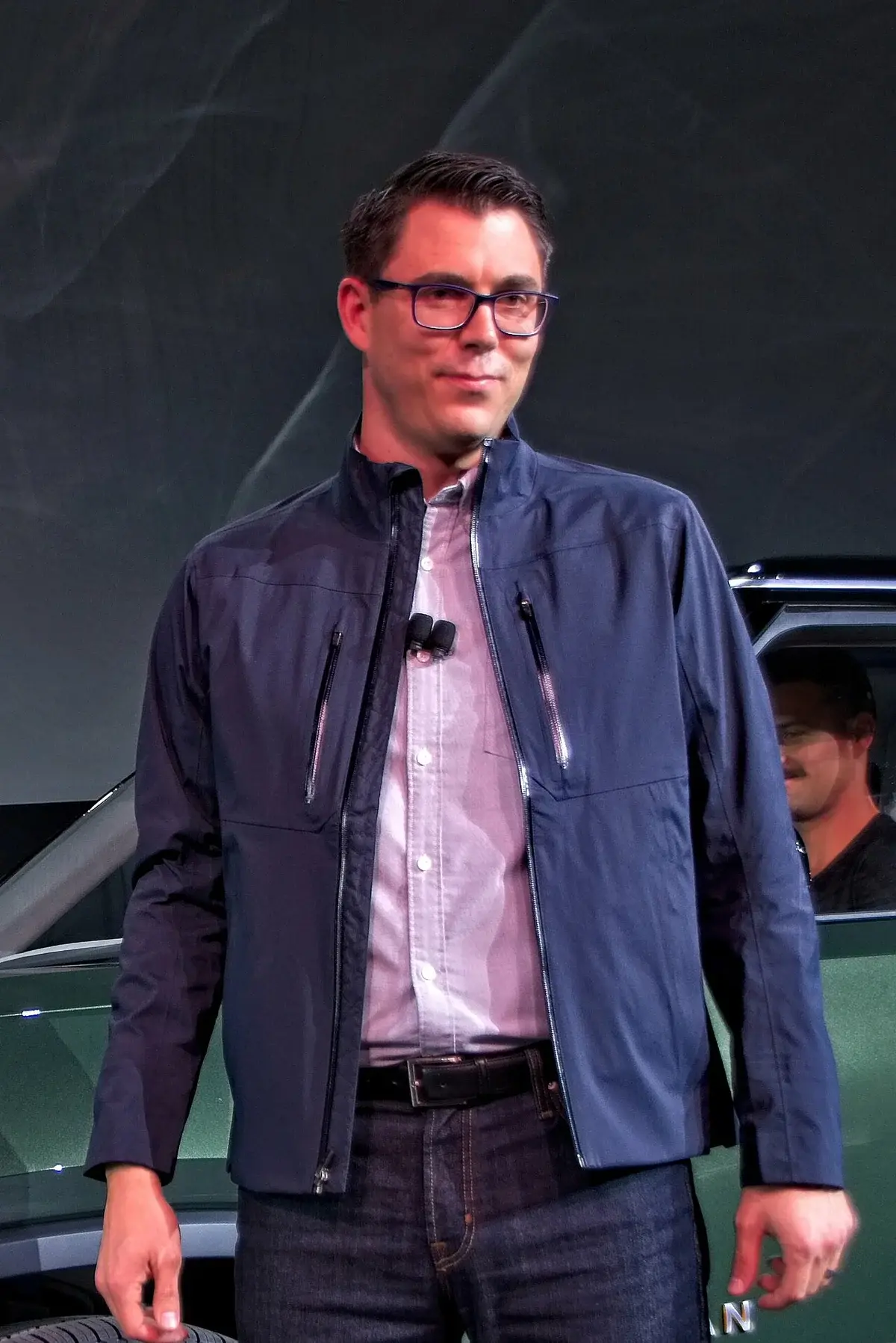 RJ Scaringe standing onstage at the Rivian R1S debut.