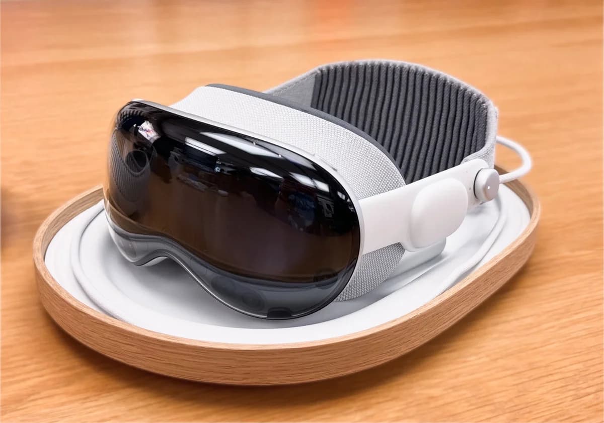 A modern VR headset sitting on a wooden table in a tray.