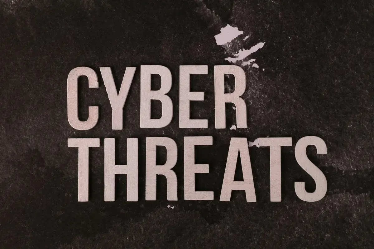 The words cyber threats on a dark textured background.