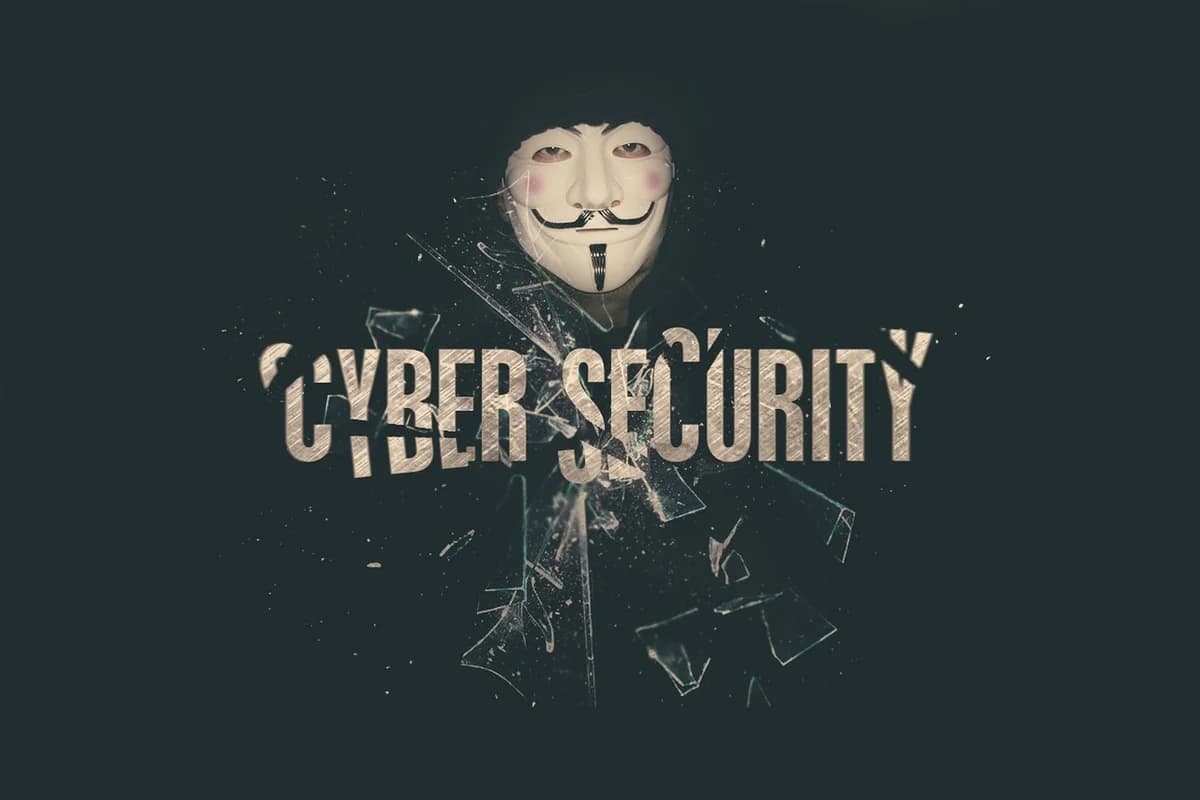 Masked figure with the words cyber security and shattered glass effects.